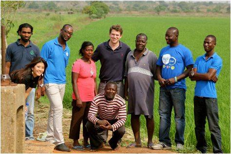 Members of the Tigo Cash team, wearing their trademark blue T-shirts, visit the Copa Connect pilot site to bring mobile money to rural Ghana. At the far left are the author with Copa Connect’s agronomist. At the center are Acumen Global Fellows Manager John McKinley flanked by several Copa Connect smallholder farmers.