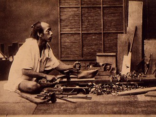 A Japanese woodworker uses the traditional tools of his trade in a photograph taken in the early years of the Meiji era (1868–1912). The furniture, boxes, and other objects such master craftsmen created were works of art by today