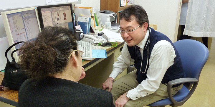 A primary care physician listens to a patient explain her symptoms. ©KyodoNews