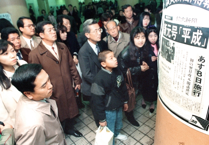 An extra edition of the Yomiuri Shimbun, posted at an Osaka subway station, announces the name of the new nengo, Heisei, on January 7, 1989. ©Kyodo News