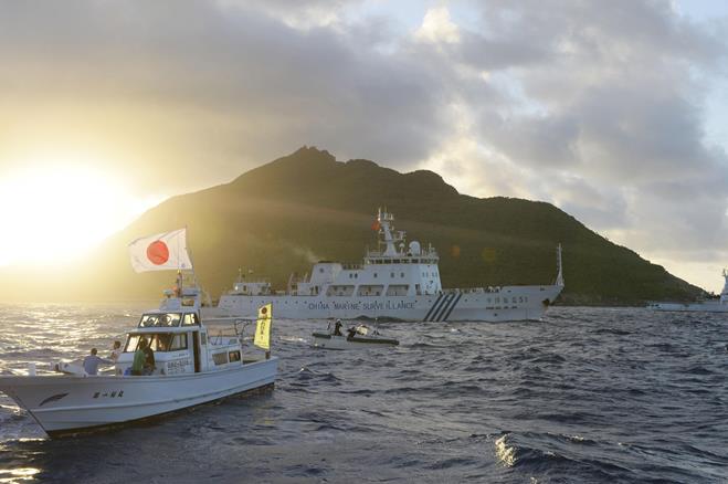 A boat chartered by a Japanese political organization and a Chinese patrol vessel ply the waters around the Senkaku Islands. ©Kyodo News