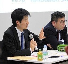 Kaoru Iokibe, holding microphone, and Kazuo Komiya.